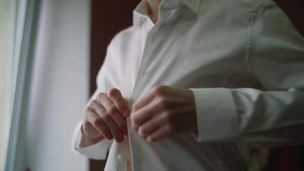 Κοντινό πλάνο του άνδρα που ντύνεται και κουμπώνει κουμπιά στο πουκάμισο στο σπίτι. Κάποιος κουμπώνει το πουκάμισό του. Άνθρωποι, επιχειρήσεις, μόδα — Αρχείο Βίντεο