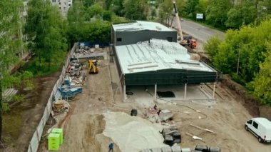 Binanın inşaat deposundaki havadan çekimi, perakende alanı. Büyük inşaat işçisi Midle shot 'ta çalışıyor.