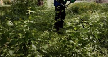 İşçi çimleri çim biçme makinesiyle biçiyor, yavaş çekimde. Yaklaş. Ön görünüm