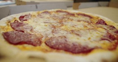 Pizza kesicisiyle pizzayı dilimleyen biri yavaş hareket eder. Yakın plan..