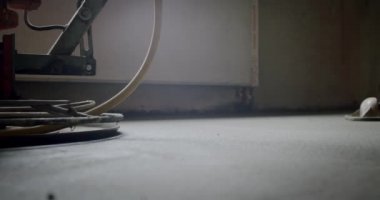 Yeni apartmanların inşaat alanında havan cilası döşeyen bir müteahhit. Ağır çekimde yakın çekim.