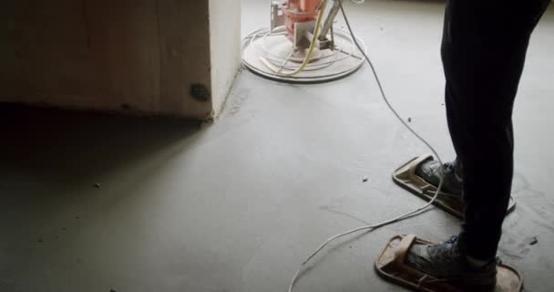 Builder polishing mortar floor at construction site of new apartments. Замедленная съемка . — стоковое видео