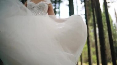 Gelin beyaz bir gelinlik içinde dönüyor. Yavaş çekim. Yakın çekim.