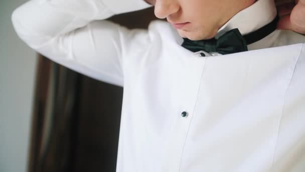 Το πρωινό του γαμπρού, δένει μια γραβάτα σε ένα λευκό πουκάμισο. — Αρχείο Βίντεο