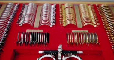 Kapatın. Gözlükçü laboratuarında gözlükçü diopter aletleri ve lenslerle dolu bir çanta. Görüş testi için teşhis lensi kiti