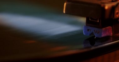 Müzik plakası boyunca çalışan vinil pikaplı pikap. Neon ışığı. Kapat.