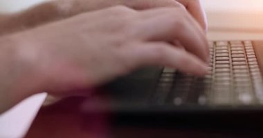 Kapatın. Ofis günışığında tuşlara yazı yazan bir adam. Kaydırma kamerası