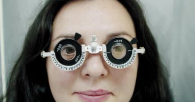Optik foropteri olan genç bir kadının görüş ölçüsünü kapat. Göz testi yapan kadın Ağır çekim