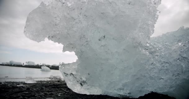 Ghiaccio cristallino che si scioglie sulla spiaggia vulcanica di Diamond Beach in Islanda o Jokulsarlon. Goccia acqua — Video Stock