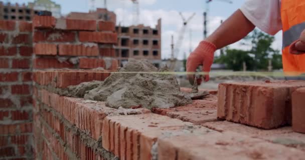 Erkek işçiler betonla duvara tuğla döşüyorlar. Kapat. — Stok video