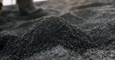 Mens 'in yavaş hareket eden elleri Reynisfjara Kara Kum Kumsalı' ndaki siyah volkanik kumu parmaklarından içeri taşır. V6