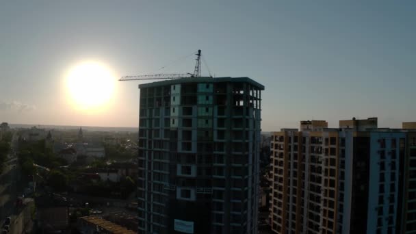 Vue aérienne par drone de la construction à la lumière du coucher du soleil. Bâtiment du chantier de construction en ville. voler autour — Video
