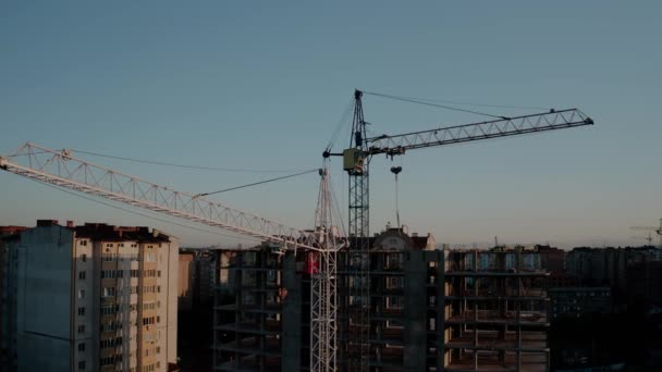 Letecký pohled na stavební jeřáby při západu slunce. Stavební budova ve městě. V2 — Stock video