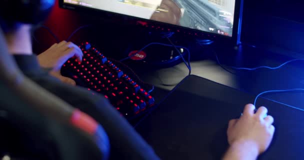 Κοντινό πλάνο στα χέρια του παίκτη Παίζοντας στο παιχνίδι βίντεο Χρησιμοποιώντας το ποντίκι και το πληκτρολόγιο φόντο με δροσερά φώτα νέον. Άνω όψη — Αρχείο Βίντεο