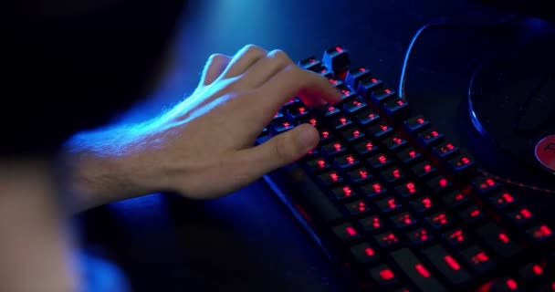 Nahaufnahme auf den Händen des Spielers, der im Videospiel mit Tastatur-Hintergrund und coolen Neonlichtern spielt. V4 — Stockvideo