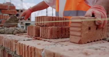 Erkek işçiler betonla duvara tuğla döşüyorlar. V2 'yi kapat
