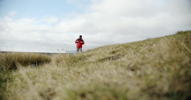 Vista de un hombre piernas en botas caminando sobre musgo verde y hierba en iceland . — Vídeos de Stock