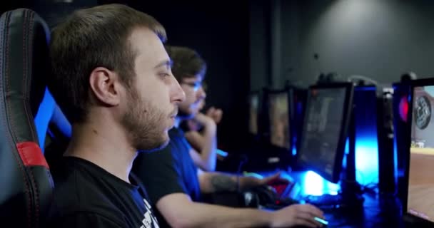 Zwei Spieler setzen sich Kopfhörer mit Mikrofon auf und spielen aus nächster Nähe ein Online-Videospiel. , Kamera bewegen — Stockvideo