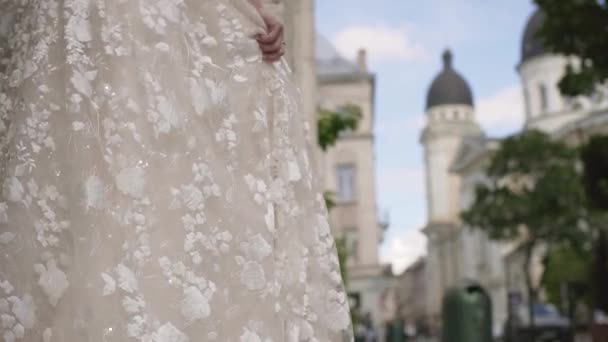 Молодая невеста в свадебном платье кружит в старом городе. элемент вращает свадебное платье невесты — стоковое видео
