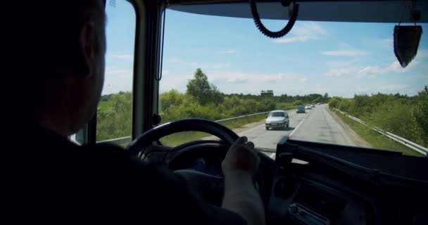Водій вантажівки Вид на людину, яка водить машину на сільській дорозі в теплий літній день. Повільний рух — стокове відео