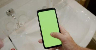 Banyoda Yeşil Ekran Cep Telefonu Kullanan Adam.