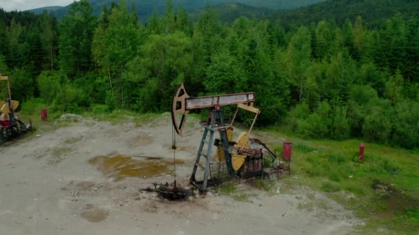 Vista aérea del dron Flight Past Working Pumpjack gato bomba de aceite industrial de trabajo y bombeo de petróleo crudo para la energía de combustibles fósiles con plataforma de perforación. V2 — Vídeo de stock