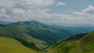 Hava aracı görüntüsü. Ağaçsız yeşil dağlar, dağlarda Dogyaska Gölü mavi gökyüzünün arka planında Svydovets Dragobrat V5