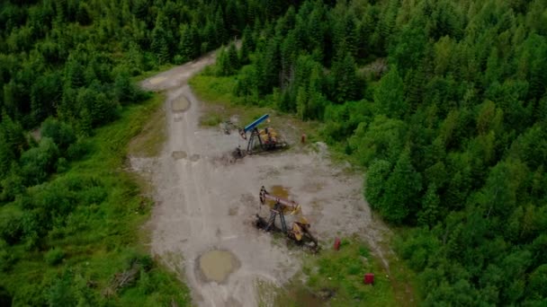 Aerial Drone view Flight Past Working Pumpjack industrial oil pump jack working and pumping crude oil for fossil fuel energy with drilling rig. Widok z góry — Wideo stockowe