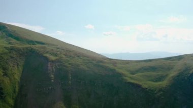 Hava aracı görüntüsü. Ağaçsız yeşil dağlar, mavi gökyüzünün arka planında Svydovets V4 Dragobrat