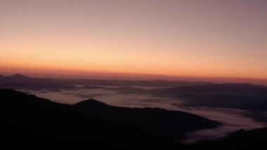 Hava aracı hala görünüyor. Dağlarda gün doğumu ya da gün batımı, güneşin altında ağaçların üzerinden uçmak...