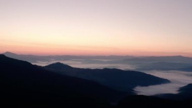Hava aracı hala görünüyor. Dağlarda gün doğumu ya da gün batımı, güneşin altında ağaçların üzerinden uçmak...