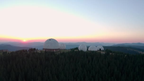 Drohnenblick aus der Luft, ungewöhnliches Architekturkonzept. Sonnenuntergang über der einzigartig gestalteten alten Radarstation Pamir in Form weißer Kugeln in Berg-V8 — Stockvideo