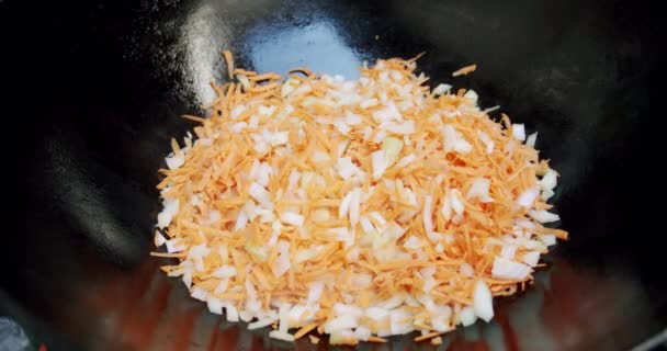 Muy cerca, las manos de los cocineros arrojan las zanahorias en una sartén. — Vídeo de stock