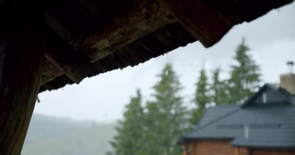 Água da chuva caindo do telhado de azulejo marrom em tempo de dia. Movimento lento — Vídeo de Stock