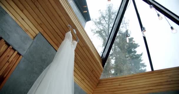 Robe de mariée blanche suspendue au mur dans une chambre luxueuse. — Video