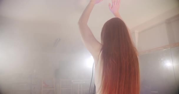 La cantante se para con su espalda a la cámara y comienza a cantar, la escena en el humo — Vídeos de Stock