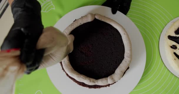 De cerca. Manos de mujer haciendo pastel con crema blanca y galleta. Vista superior — Vídeo de stock