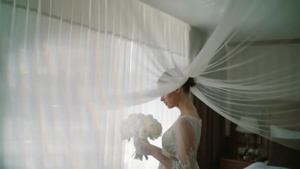 Ранок нареченої в білих трояндах тримає в руках весільний букет з троянд. Стоячи біля вікна Крупним планом . — стокове відео