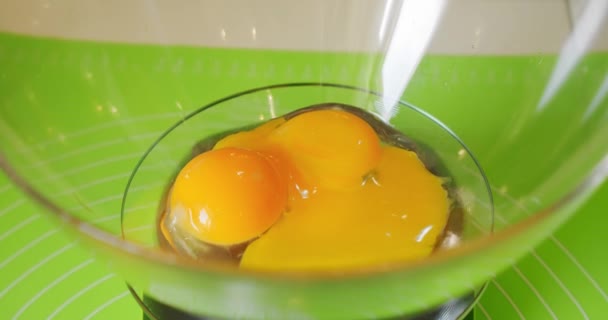 Женские руки разбивают сырые яйца, чтобы сделать торт и сливки. Закрыть — стоковое видео
