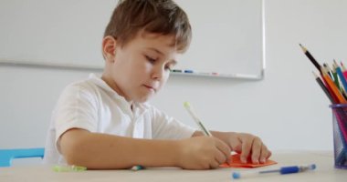 Kalemle resim çizen küçük tatlı çocuk evde ya da anaokulunda yaratıcılıkla uğraşıyor. Okul öncesi hazırlık.