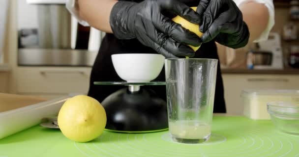 Chef en guantes negros exprime limón, ingredientes naturales crudos, Primer plano. Movimiento lento — Vídeos de Stock