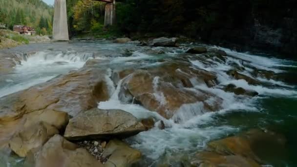 Hava aracı görüntüsü. Dağ nehri, bir dağ deresinin üzerinden uçuyor, akıntılı küçük kayalar. — Stok video