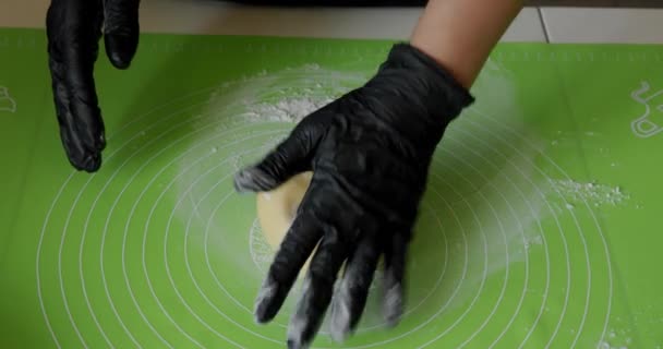 Aus nächster Nähe. Chef-Hände in schwarzen Handschuhen bereiten den Kuchen zu oder legen Pizzateig an Bord. V6 — Stockvideo