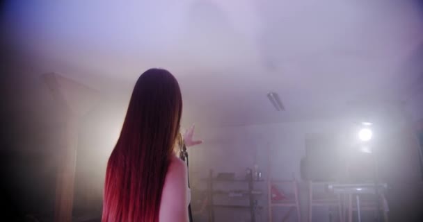 The girl singer stands with her back to the camera and begins to sing, the scene in smoke V4 — Stock Video