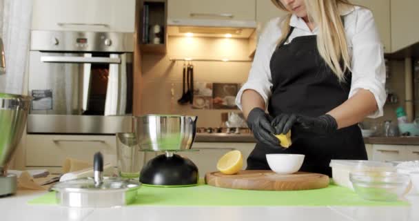 Шеф-повар в черных перчатках сжимает лимон, сырые натуральные ингредиенты, закрыть. Медленное движение V5 — стоковое видео