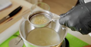 Siyah eldivenli şef limon sıkar, çiğ doğal malzemeler. Yavaş çekim V6