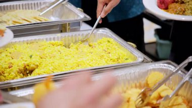 Konukların Asya büfesi yemeklerinin keyfini çıkarırken yakın plan çekimleri. Etkinlikte çeşitli yiyeceklerle birlikte. Manzaranın üstünde. Yüksek kalite 4k görüntü