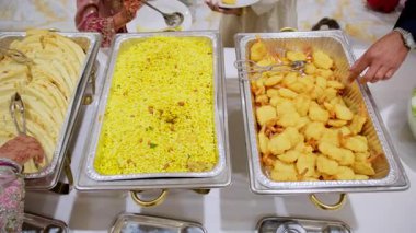 Konukların Asya büfesinin tadını çıkarırken yakın plan çekimleri. Etkinlik sırasında çeşitli lezzetli yiyeceklerle birlikte. Manzaranın üstünde. Yüksek kalite 4k görüntü