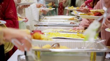 Konukların Asya büfe yemeklerinin keyfini çıkarırken yakın plan çekimleri. Etkinlik sırasında çeşitli yiyeceklerle birlikte. Manzaranın üstünde. Yüksek kalite 4k görüntü