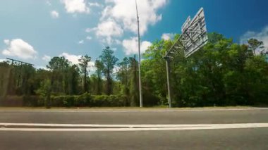 Aydınlık güneşli bir günde otobanda araba kullanan yolcu tarafından POV görüntüsü. Araba köprünün altından geçiyor. Parlak mavi bahar gökyüzü. Yüksek kalite 4k görüntü